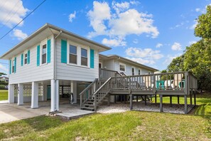 A two-story house with a covered porch and a staircase leading to a deck. - Beachside Bliss on 11th Street | 3 Minute Walk to Beach (Emerald Isle)