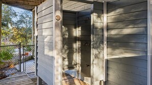 A wooden deck leading to a covered outdoor area with a metal gate. - Family Retreat with Hot Tub & Game Room and Short Walk to Beach (Emerald Isle)