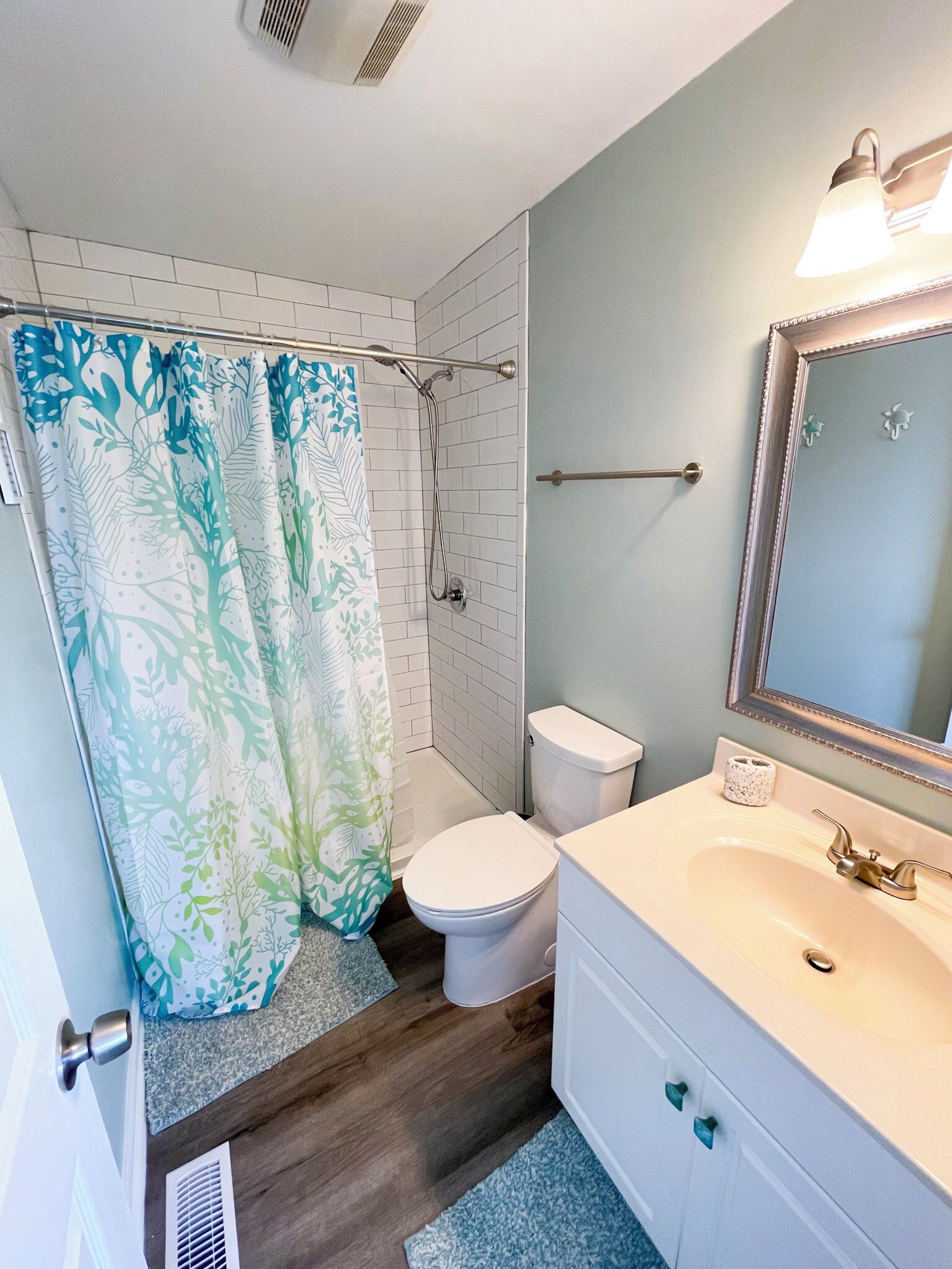 Une salle de bain équipée d’une douche, de toilettes, d’un lavabo et d’un miroir.