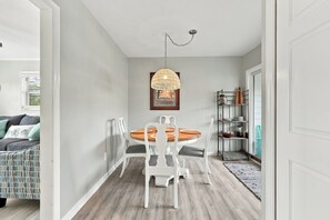 Gather around the elegant round table in your own charming dining space, where a woven pendant casts warm light over meals and conversation. The high ceilings and open doorways create an airy, welcoming feel perfect for relaxing evenings together. - 3-bedroom, 2.5-bathroom townhome| Walk to beach (Emerald Isle)