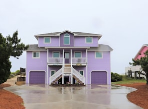 A two-story house with a front porch, a staircase, and a garage. - Ocean Front Beach Home 4BR – Views, Decks & Beach Access (Emerald Isle)