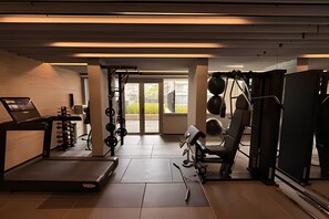 A gym with a treadmill, weightlifting equipment, and exercise machines. - Condomínio Helbor Edition  (São Paulo)