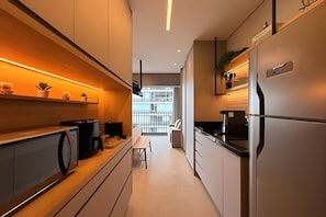 Uma cozinha moderna com uma bancada comprida, eletrodomésticos embutidos e vista para o exterior.