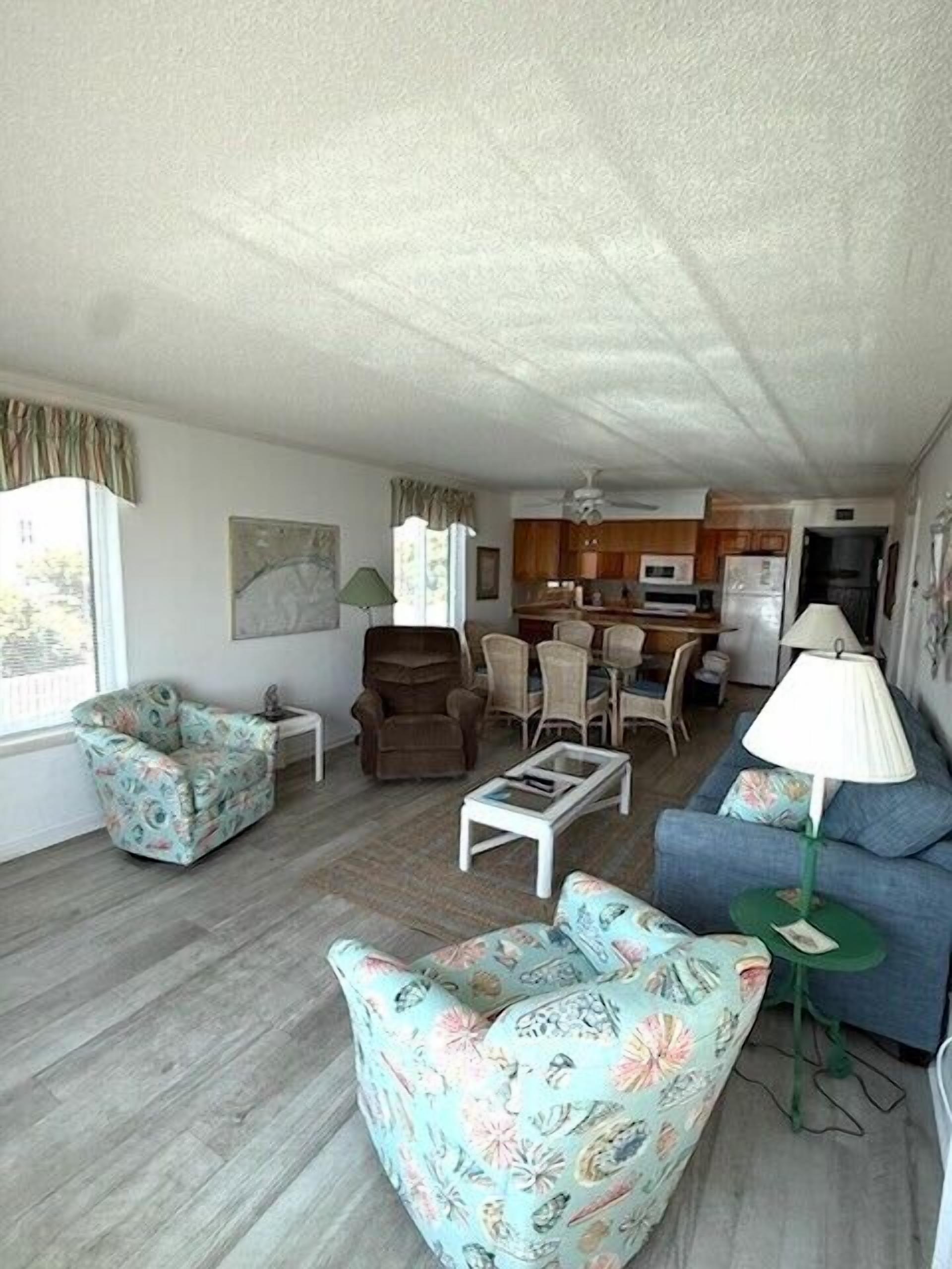 A compact living space with a kitchenette, a dining area, and a seating area with a sofa and armchairs.