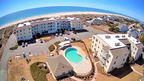 Un hotel amb piscina, aparcament i vista al mar.
