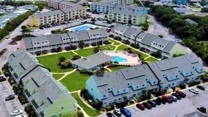 Un gran complejo hotelero con varias edificaciones, piscina y estacionamiento.
