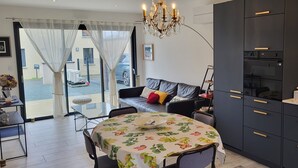 Una sala moderna con una mesa de comedor, sofá y área de cocina.