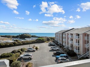 Ein Küstenhotel mit mehrstöckigen Gebäuden, einem Parkplatz und Meerblick.