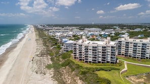 A coastal hotel with multiple floors, a beach view, and a parking area. - Oceanfront 3BR Condo with Views, Pool & Beach Access (Emerald Isle)