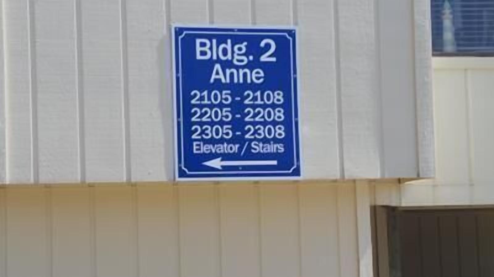 A directional sign for Bldg. 2 Anne with room numbers 2105-2108, 2205-2208, and 2305-2308, indicating elevator/stair access.