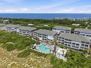 A resort with multiple buildings, a central pool area, and a view of the ocean. - Oceanfront, poolside condo with sound side access (Indian Beach)