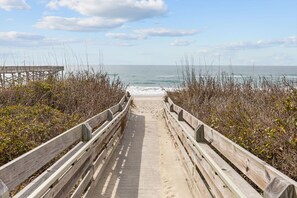 A wooden boardwalk leading to the beach with a pier in the background. - Spacious poolside 4BR short walk to the beach! (Atlantic Beach)