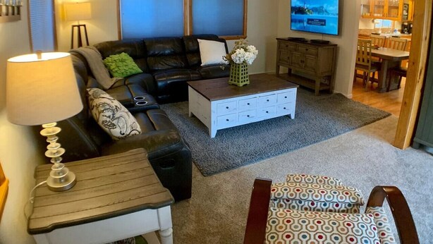 A living room with a sofa, coffee table, and TV. - Cozy Cascade Retreat (Cascade)