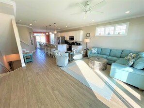A spacious living area with a sofa, a coffee table, and a kitchen in the background.