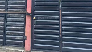 Una entrada con portón y un letrero que indica apartamento y garaje.