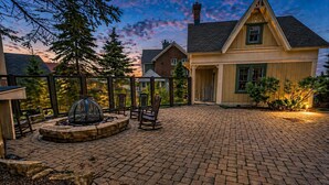 A patio with a fire pit, seating, and a view of a house. - AS 110: Luxury Summer Getaway | Cool Temps, Trails & Mountain Views (Snowshoe)