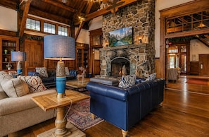 A spacious lobby with a stone fireplace, leather sofas, and a wooden coffee table.