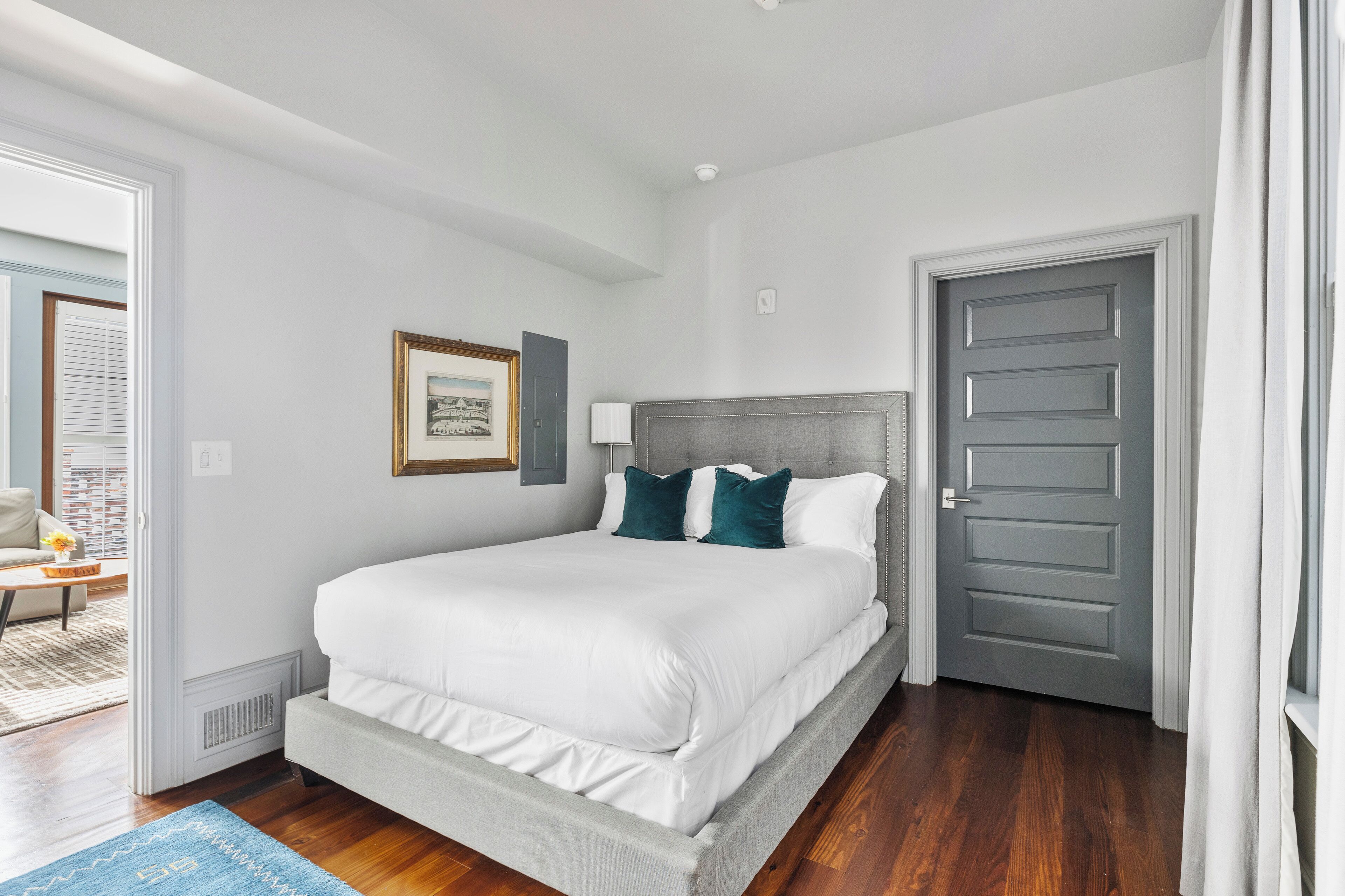 Une chambre à coucher avec un lit, une porte et une fenêtre.
