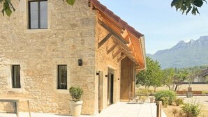 A stone building with a covered patio and a view of mountains. - LA VILLA DE PAUL - YENNE (YENNE)