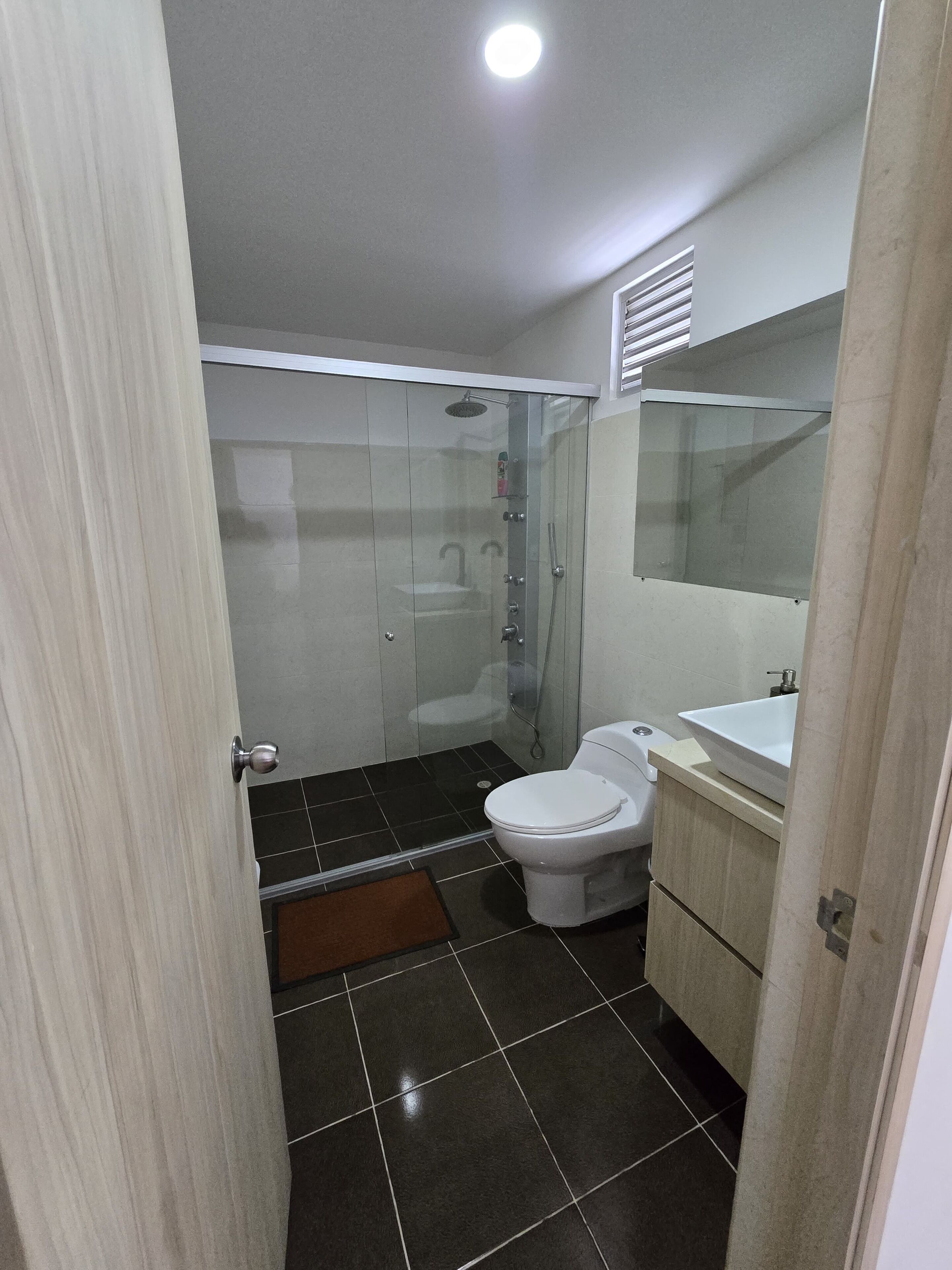 Ein Badezimmer mit Toilette, Waschbecken und Duschbereich.