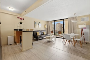 Ein modernes Apartment mit Küche, Wohnbereich, Essbereich und einem Balkon mit Blick auf die Stadt.