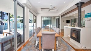 Ein modernes Interieur mit Essbereich, Kamin und Blick ins Freie.