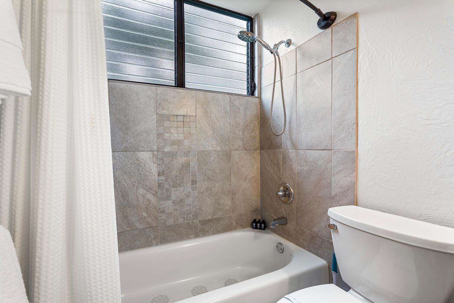 Une salle de bain avec une baignoire, une douche et des toilettes.