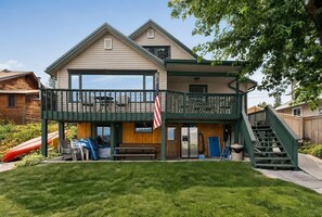 A two-story building with a covered patio area, a flag, and a staircase leading to the upper level.