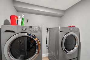 Two front-loading washing machines in a laundry room with a gray wall and a ceiling light fixture. - Diamond Lake Retreat w Private Beach & Dock! (Newport)