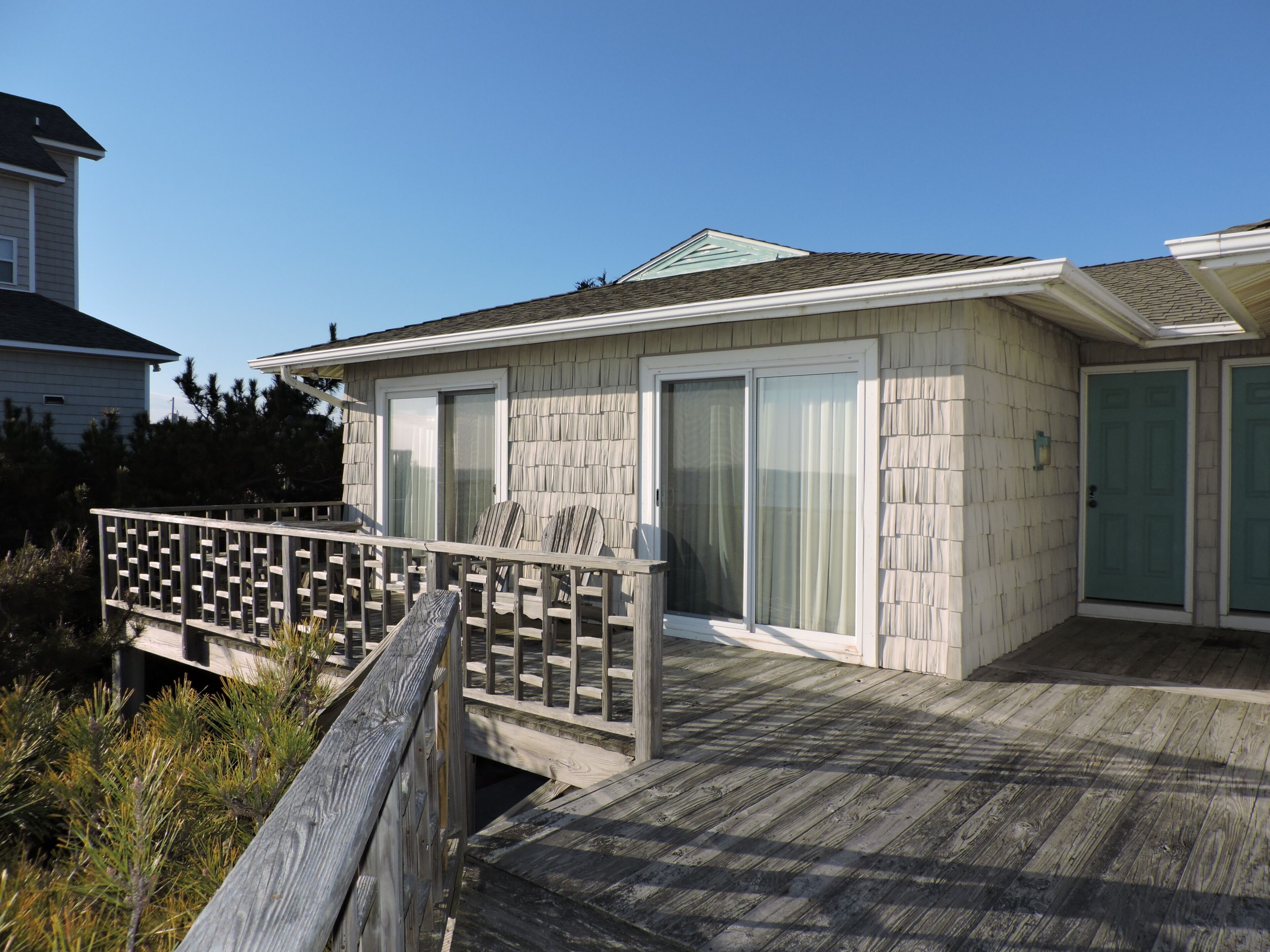 A house with a deck, a covered porch, and a garage.