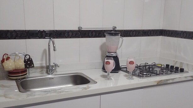 Cuina amb un rentaplat, una batedora i una cuina de gas.