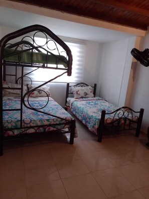 A room with two bunk beds, a window with blinds, and a hanging item. - SPACIOUS HOUSE WITH PATIO (Santa Marta)
