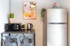 Eine Küchenzeile mit Toaster, Kaffeemaschine, Wasserkocher und einer Zimmerpflanze.