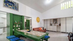A spacious living area with a green dining table, a brown sofa, and a kitchen in the background. - House w. 5-br and Pool 200m From the Beach Fpl0228 (Cabedelo)
