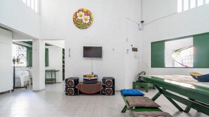 A room with a television, speakers, a table, and a bench. - House w. 5-br and Pool 200m From the Beach Fpl0228 (Cabedelo)