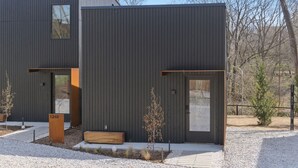 Ein modernes, zweistöckiges Gebäude mit dunkler Fassade, einem kleinen Fenster und einem Briefkasten mit der Aufschrift '1248'.