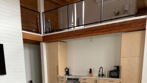 A modern kitchen with a built-in oven, microwave, and coffee maker.