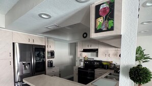 A modern kitchen with stainless steel appliances, a marble countertop, and a potted plant. - Sun, Pool & Beach: Largo Getaway (Largo)