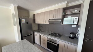 A modern kitchen with a refrigerator, stove, oven, and a built-in phone. - La Serena family vacations (La Serena)