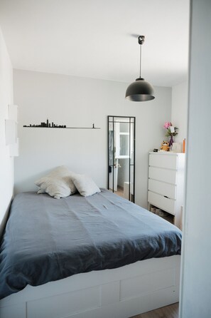 A bedroom with a bed, a dresser, a mirror, and a city skyline wall art. - Charming house 5mn away from Valbonne, in a residence with pool and tennis (Opio)