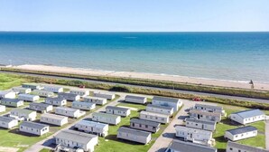 A row of mobile homes with a beach and ocean view. - cosy camber home from home caravan (Camber)