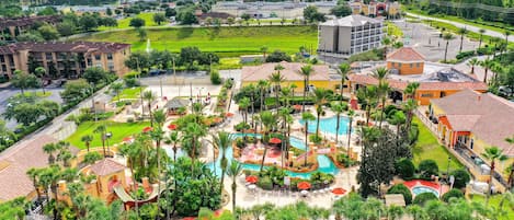 Un resort con piscina, palmeras y vistas del entorno.