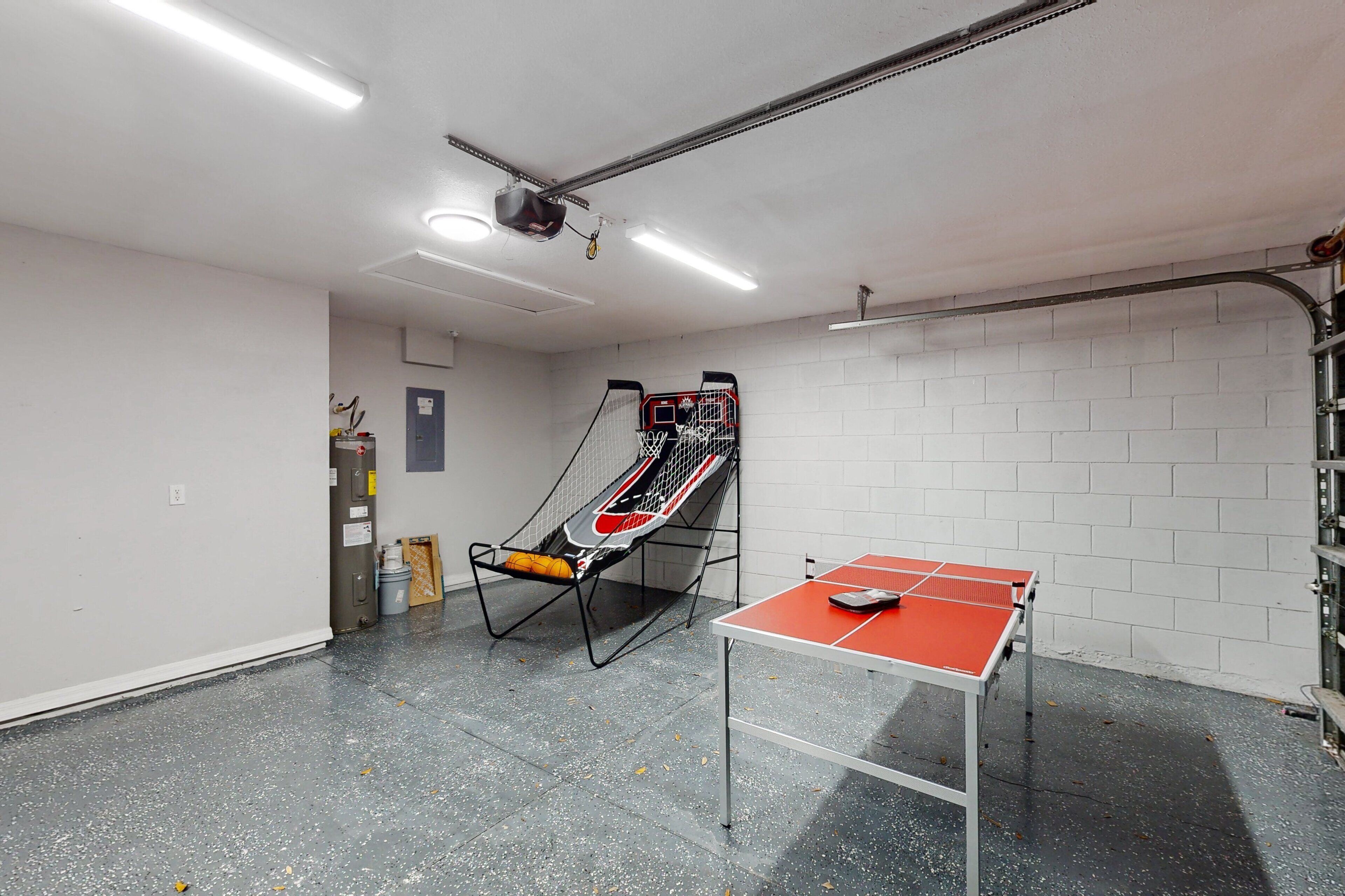 A ping pong table, a basketball hoop, and a seating area with a basketball net.