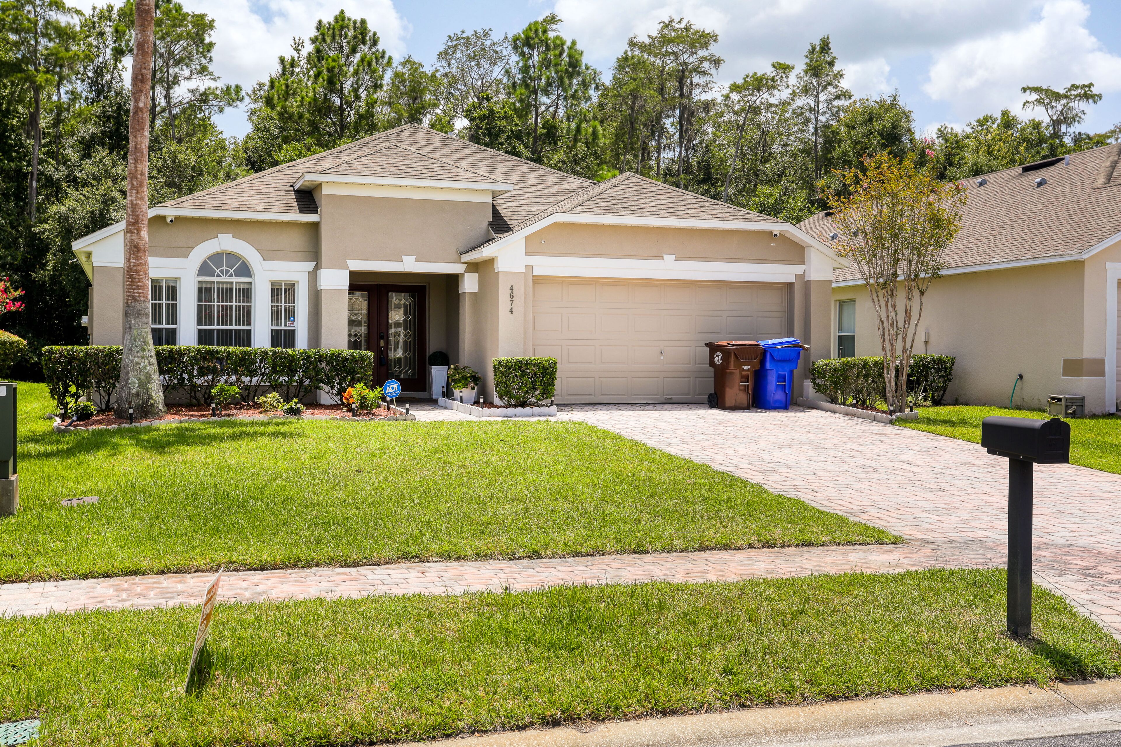 A residential house with a garage, a well-maintained lawn, and a mailbox.