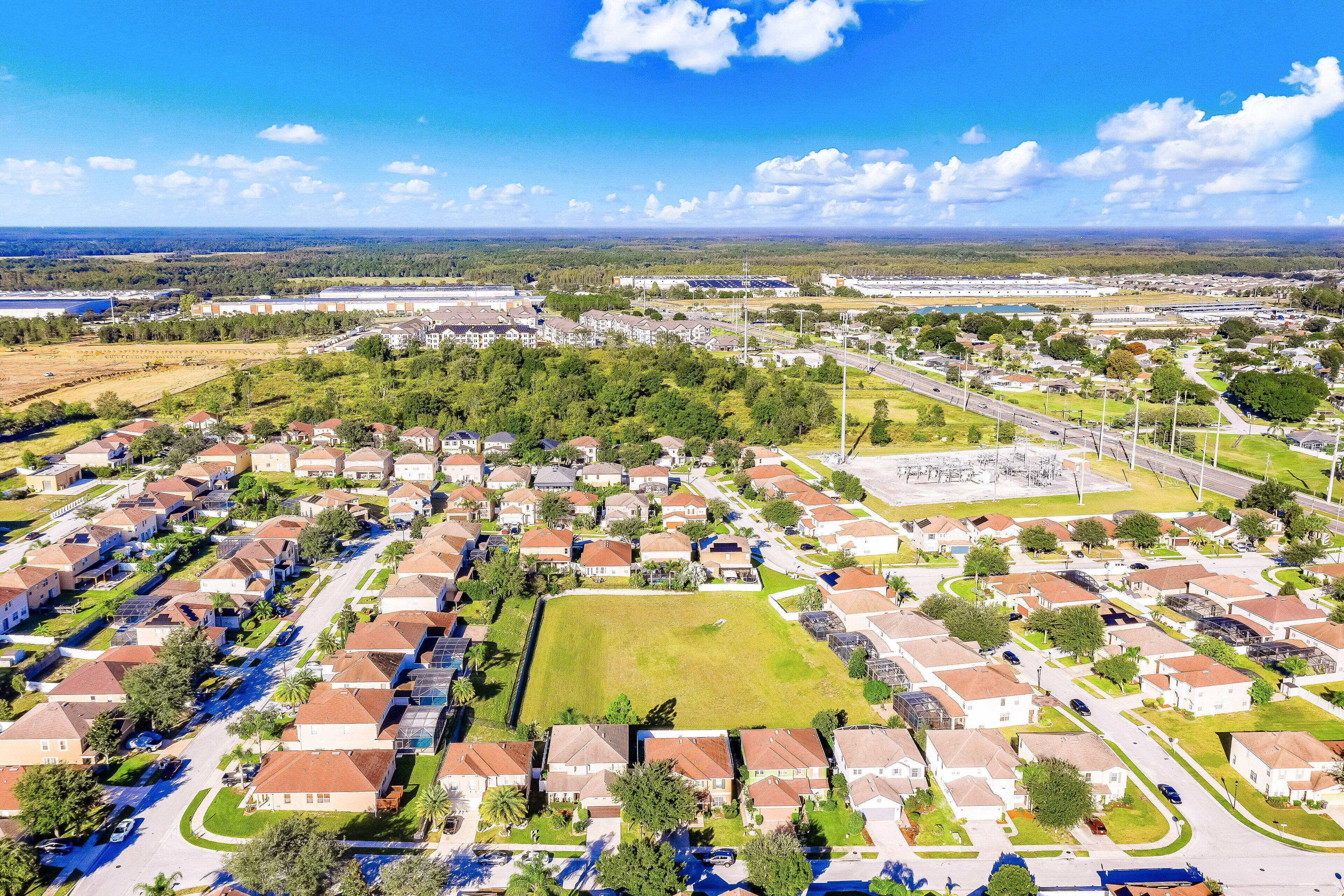 A residential area with houses, roads, and a large open field.