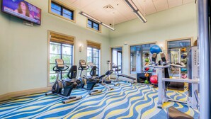 A gym with exercise equipment, a patterned carpet, and windows with blinds. - Family Home Boasting Entertainment for Everyone With Wifi (Davenport)