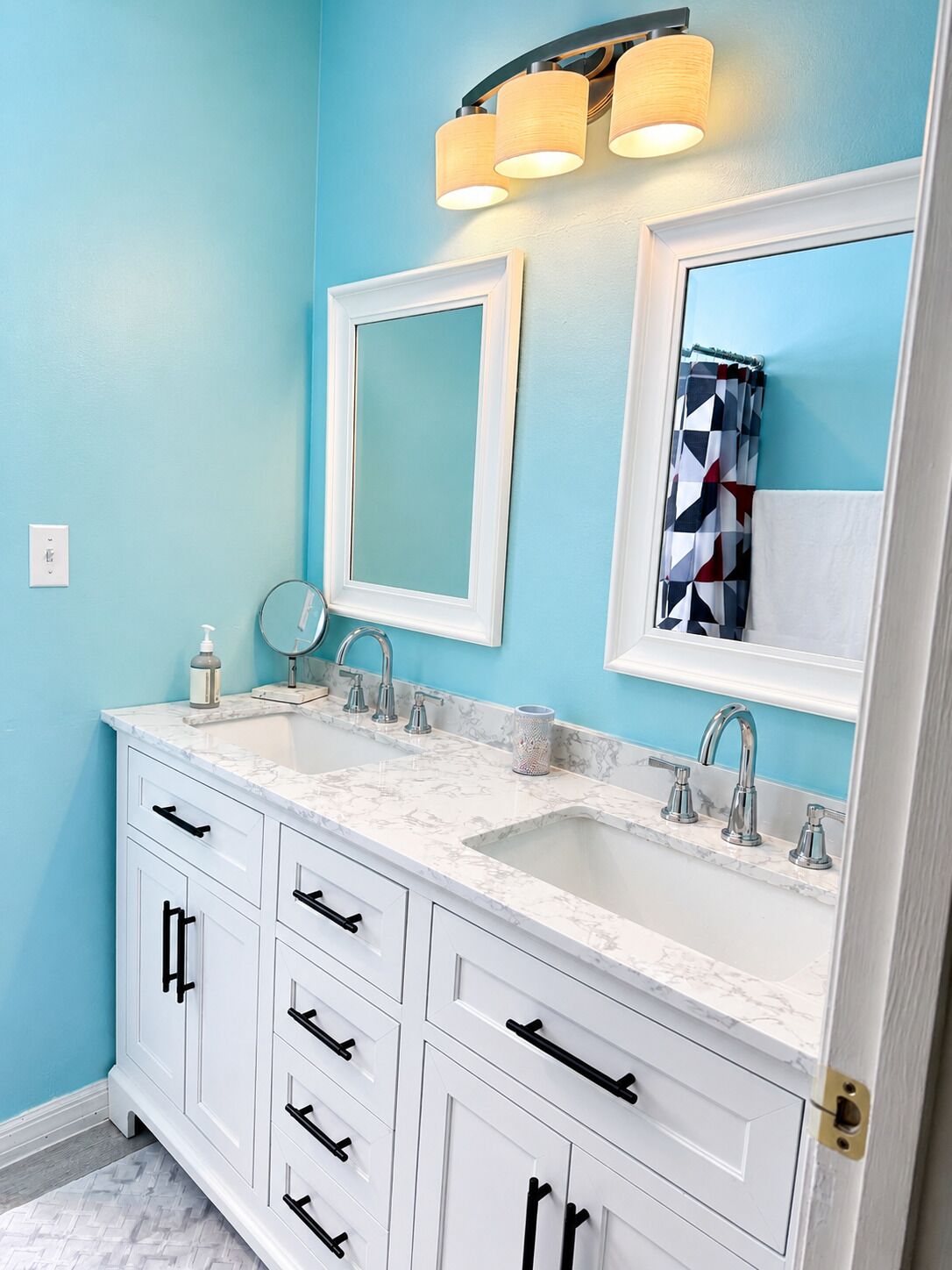 A bathroom with two sinks, a mirror, and a cabinet.