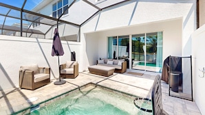A modern outdoor living area with a pool, seating, and a covered patio. - Beautiful Home With Private Pool and Space for the Whole Family (Clermont)