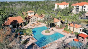 A resort with a large swimming pool, lounge areas, and a view of the surrounding forest. - Resort Condo With Heated Pool, Gym, BBQ Area, Balcony, W/d, Children's Pool, AC (Davenport)