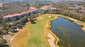 An aerial view of a residential area with apartment buildings, a golf course, and a body of water. - Resort Condo With Heated Pool, Gym, BBQ Area, Balcony, W/d, Children's Pool, AC (Davenport)
